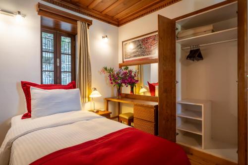 Un dormitorio con una cama roja y blanca y una ventana en Ionia House, en Selçuk