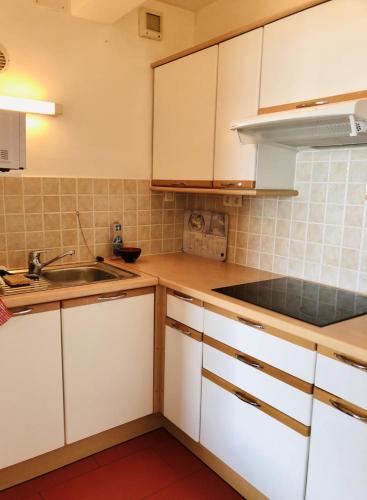 une cuisine avec des armoires blanches et un évier dans l'établissement Studio And Terrace Sea View In La Baule, à La Baule