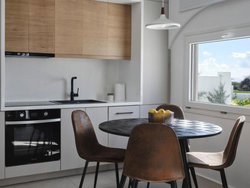 a kitchen with a table and chairs and a window at Maestro Villas Naxos in Naxos Chora