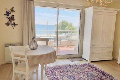 une salle à manger avec une table et une vue sur l'océan dans l'établissement Studio And Terrace Sea View In La Baule, à La Baule