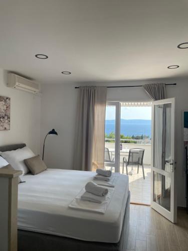 a bedroom with a bed with a view of the ocean at Apartmani Tomaš in Tučepi
