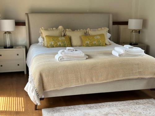 a bedroom with a bed with towels on it at Garden Cottage in Henley on Thames