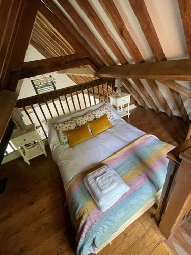 a large bed in a room with a wooden ceiling at Garden Cottage in Henley on Thames