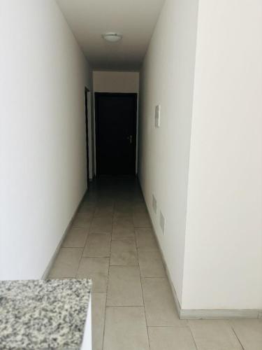 an empty hallway with a black door and a tile floor at Matis Appartamenti in Camisano