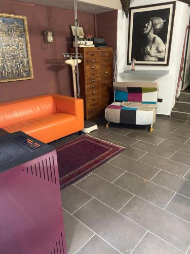 uma sala de estar com um sofá laranja e uma cómoda em Villa Gioia em Acqui Terme