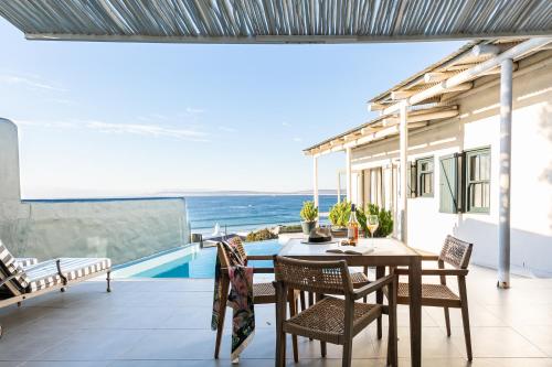 einen Balkon mit einem Tisch und Stühlen sowie Meerblick in der Unterkunft Abalone Hotel & Villa's in Paternoster
