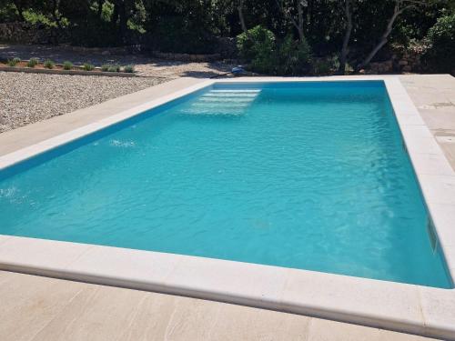 a swimming pool with blue water in a yard at Quaint holiday home in Mandre with private garden in Mandre