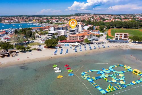 an aerial view of a beach with chairs and umbrellas at Fly Apartments Medulin - 50m from the Beach - NEW 2024 in Medulin