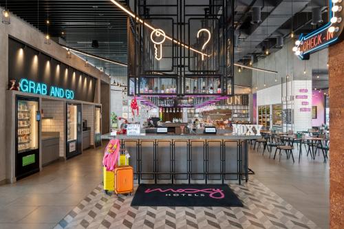 a shopping mall with a luggage cart in the middle at Moxy Bengaluru Airport Prestige Tech Cloud in Devanahalli-Bangalore