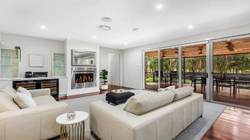 a living room with a white couch and a fireplace at The Clubhouse Pokolbin in Pokolbin