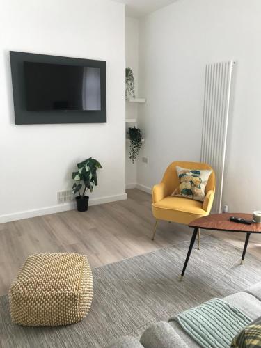 a living room with a yellow chair and a table at On The Avenue Apt 3 in Nottingham