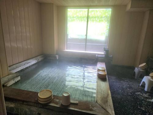 an empty room with two toilets and a window at 大和屋ホテルいろは in Nikko