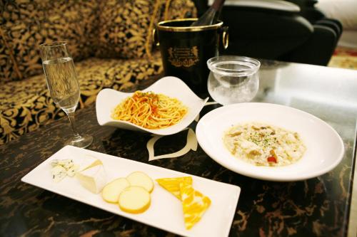 a table with two plates of food and a glass of wine at Meguro Emperor (Adult Only) in Tokyo