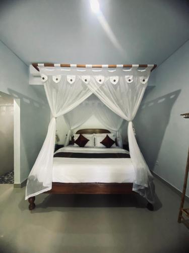 a bedroom with a bed with a canopy at Pondok Dauh Ancak in Tabanan