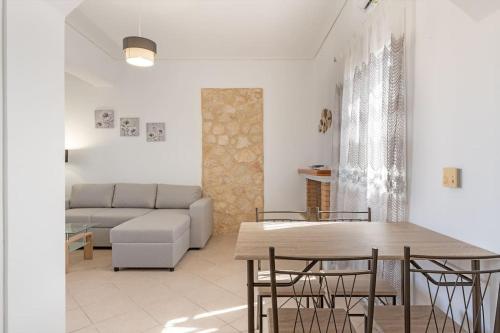 a living room with a couch and a table and chairs at Spiros house in Svoronata