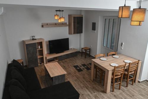 a living room with a table and a television at Mournia Apartment in Kroústas