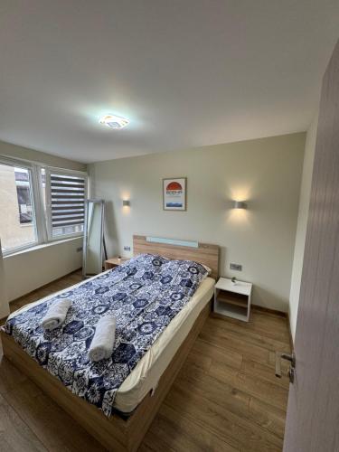 a bedroom with a bed with a blue comforter at Sea Treasure in Varna City