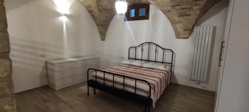 a bedroom with a bed in a white room at Appartamento di Porta Maggiore in Cupra Marittima