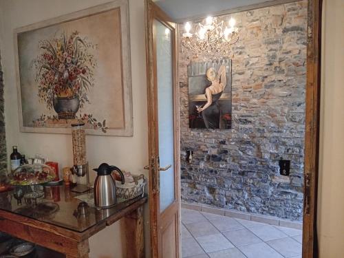 una camera con una parete in pietra, un tavolo e un quadro di Bed and Breakfast Papillon a Perledo