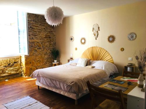 een slaapkamer met een bed en een stenen muur bij Les chambres d'Ursule in Tartas