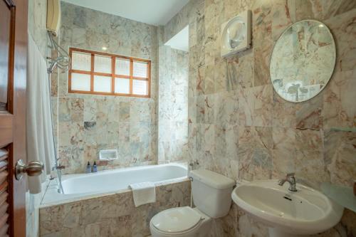 La salle de bains est pourvue de toilettes, d'un lavabo et d'une baignoire. dans l'établissement Bangtao Village Resort - SHA, à Bang Tao Beach