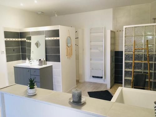 een badkamer met een bad, een wastafel en een bad bij Les chambres d'Ursule in Tartas