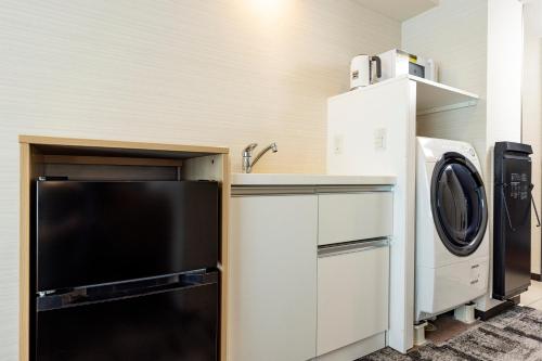 a kitchen with a sink and a washer and dryer at Tokyu Stay Tsukiji - Tokyo Ginza Area in Tokyo