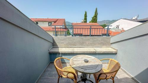a wooden table and two chairs on a balcony at Göcek Centre Hotel in Göcek