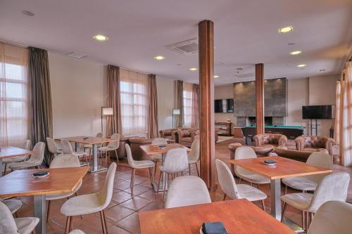 un restaurante con mesas y sillas y una mesa de billar en Hotel Spa Villa Nazules, en Chueca