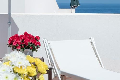 a vase of flowers sitting next to two chairs at Residence Scirocco e Tramontana in Favignana