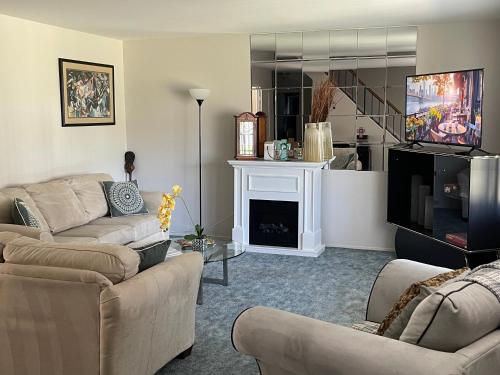 sala de estar con 2 sofás y chimenea en Stays by HOC - Pet Friendly Cozy & Comfort Cape, en Willingboro