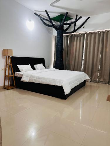 a bedroom with a bed with a tree in it at Elite stays viman nagar in Pune