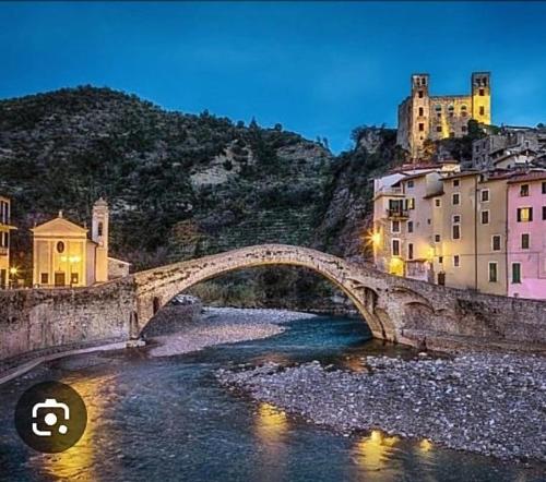 a stone bridge over a river in a city at Casa Jasmine in Camporosso