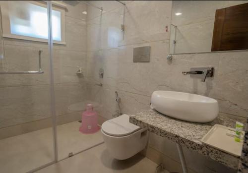 a bathroom with a toilet and a sink and a shower at Hotel Stay Casa in Bhopal