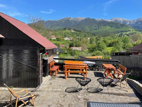 a patio with chairs and a bench and a table at Casa Hoinarilor Wanderers House in Bran