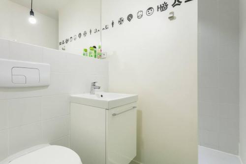 une salle de bain blanche avec un lavabo et des toilettes dans l'établissement Montpellier Studio Climatisé, à Montpellier
