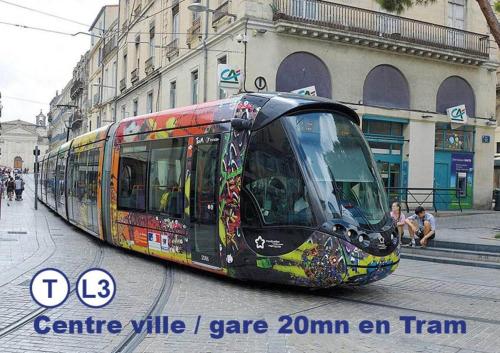 un tramway coloré dans une rue d'une ville dans l'établissement Montpellier Studio Climatisé, à Montpellier