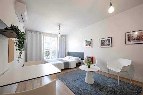- un salon blanc avec un lit et une table dans l'établissement Montpellier Studio Climatisé, à Montpellier