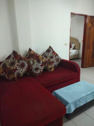 a living room with a red couch and a table at Changthai Comfort Guest House in Ban Nong Phai