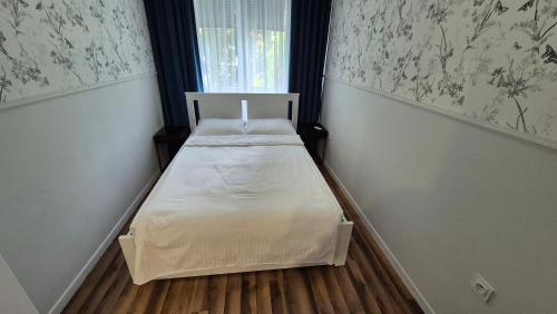 un piccolo letto in una camera con finestra di South House a Włocławek