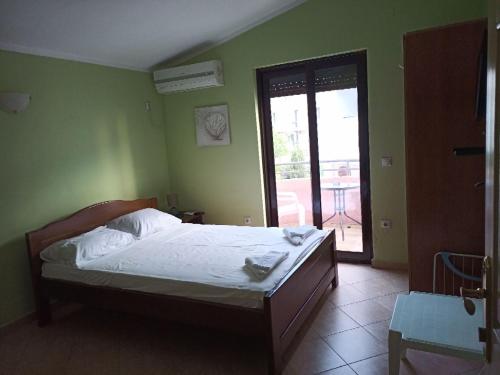 a bedroom with a bed in a green wall at Apartments Normannia in Dobra Voda