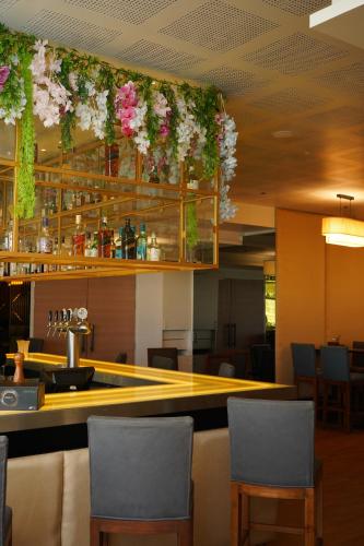 a bar in a restaurant with flowers on the ceiling at Hilton Garden Inn Pune Hinjawadi in Pune