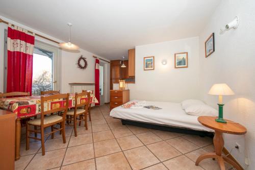 una camera con letto, tavolo e sedie di Résidence Jardins d'Androsace 17 - Happy Rentals a Chamonix-Mont-Blanc