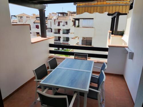 a table and chairs in a room with a balcony at Urbanización Altos de Nuevo Vera in Vera