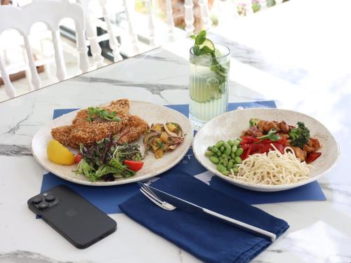 a table with two plates of food and a cell phone at Vira Otel Suites in Sinop