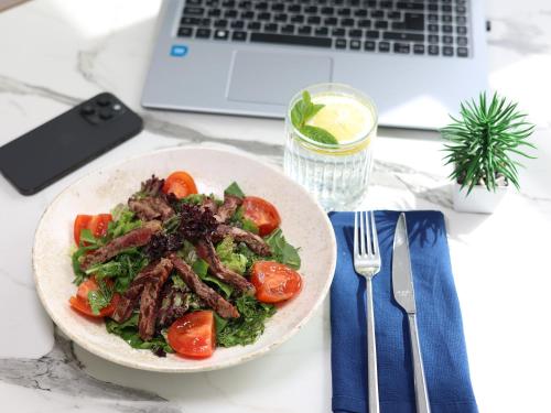 a bowl of food on a table next to a laptop at Vira Otel Suites in Sinop