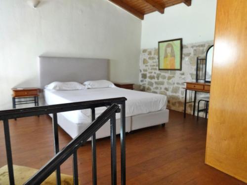 a bedroom with a white bed and a staircase at Thalassa Apartments in Rethymno