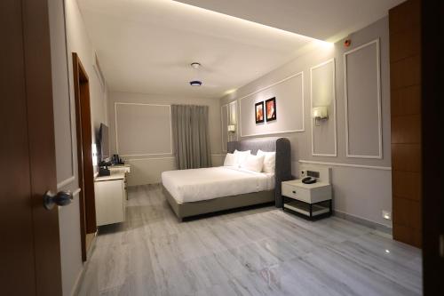 a hotel room with a bed and a bathroom at The Oaks Elite in Gulbarga