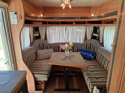 une table avec un vase de fleurs dessus dans un camping-car dans l'établissement Magnifique grande Caravane aux Gorges de Daluis, à Guillaumes