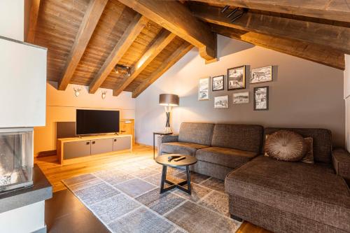 a living room with a couch and a tv at Bergresort Zugspitze Ehrwald by ALPS RESORTS in Ehrwald
